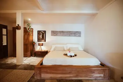 a bedroom with a large bed with a wooden frame at Oma Villa - A tropical sanctuary of Seminyak in Seminyak