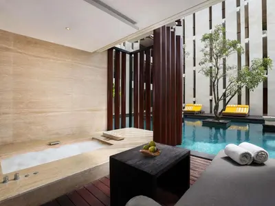 a bathroom with a tub and a swimming pool at Grand Seminyak Lifestyle Boutique Bali Resort in Seminyak