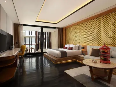 a bedroom with a bed and a desk and a television at Grand Seminyak Lifestyle Boutique Bali Resort in Seminyak