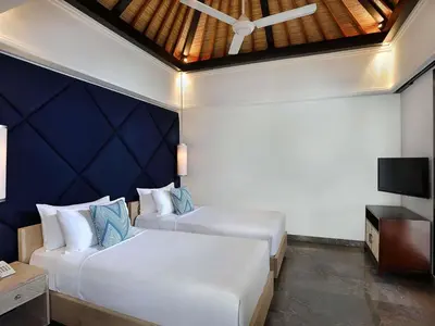 a hotel room with two beds and a tv at Peppers Seminyak in Seminyak