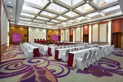a large room with rows of tables and chairs at Truntum Kuta Bali in Kuta
