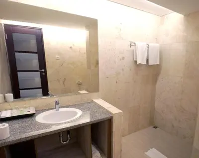a bathroom with a sink and a mirror at Truntum Kuta Bali in Kuta