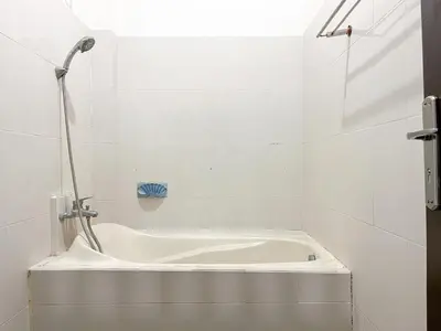 a white bath tub in a bathroom with a shower at Adi surya guest house in Seminyak