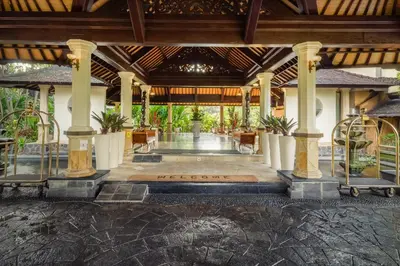 a lobby of a resort with columns and plants at Hotel Vila Lumbung in Seminyak