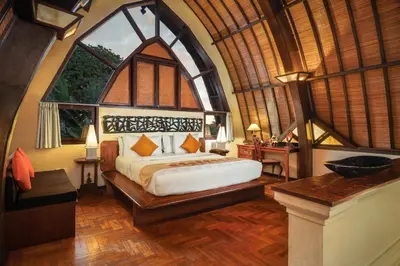 a bedroom with a bed and a large window at Hotel Vila Lumbung in Seminyak