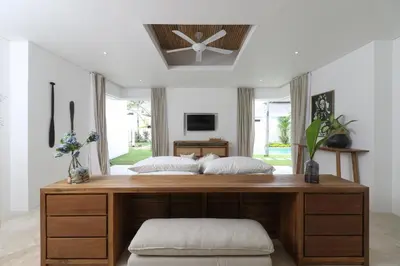 a bedroom with a large wooden bed with two pillows at The Plantation at Batu Belig in Canggu