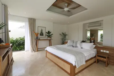 a bedroom with a bed and a ceiling fan at The Plantation at Batu Belig in Canggu
