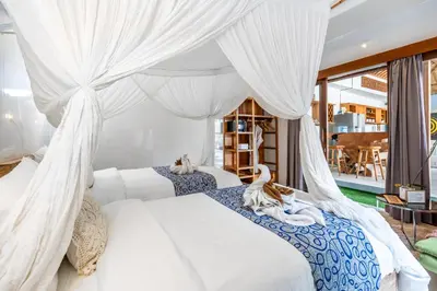 a bedroom with two cats laying on a bed at Kubu Joglo Villa in Seminyak