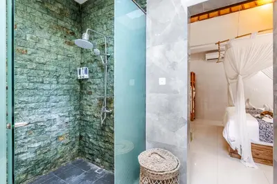 two images of a bathroom with a shower at Kubu Joglo Villa in Seminyak
