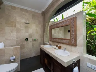 a bathroom with two sinks and a mirror at Anyar Estate in Canggu