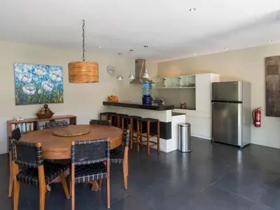 a kitchen and dining room with a table and a refrigerator at Anyar Estate in Canggu