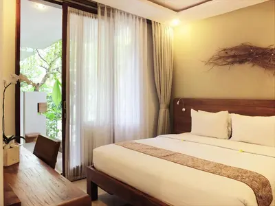 a hotel room with a bed and a window at Arana Suite in Legian