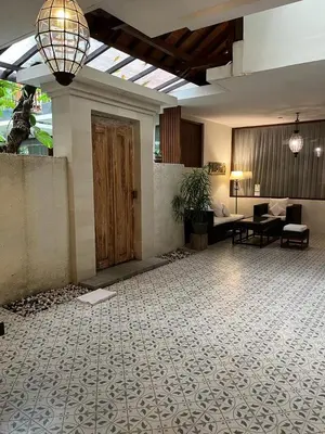 a lobby with a large room with a wooden door at Arana Suite in Legian