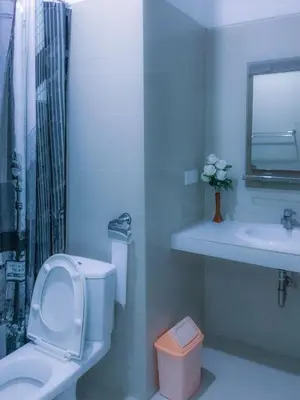 a white bathroom with a toilet and a sink at Alamanda Villa in Seminyak