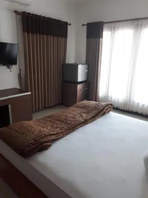 a bed with a blanket on it in a room at Alamanda Villa in Seminyak