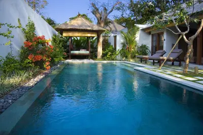 a swimming pool in a backyard with a gazebo at Villa Bali Asri in Seminyak