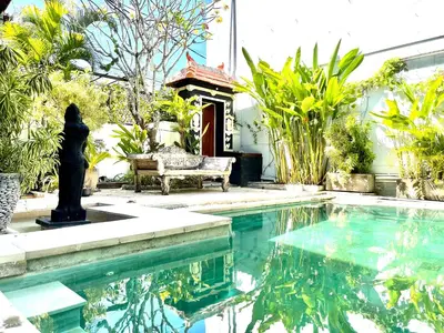 a pool with a statue and a bench in a yard at 3BR Villa Carissa Seminyak Centre, Bali by Le Ciel Hospitality in Seminyak