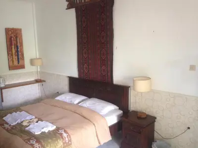 a bedroom with a bed with a wooden head board at Meriki Apartment in Seminyak