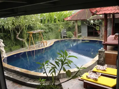 a swimming pool in a garden with a swimming pool at Meriki Apartment in Seminyak