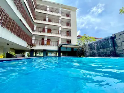 a swimming pool in front of a building at Sun Royal Hotel in Kuta