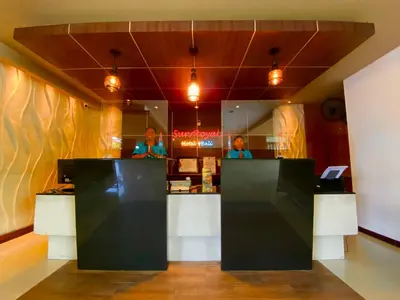 two people standing at the counter of a restaurant at Sun Royal Hotel in Kuta