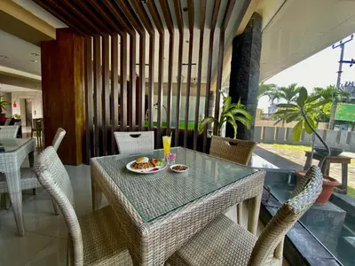 a table and chairs with a plate of food on it at Sun Royal Hotel in Kuta