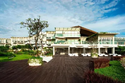 a large white building with a courtyard in front of it at Sheraton Bali Kuta Resort in Kuta