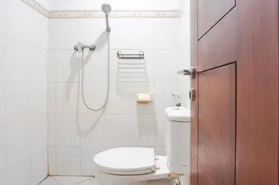 a bathroom with a shower and a toilet in it at Gana Inn Legian in Legian
