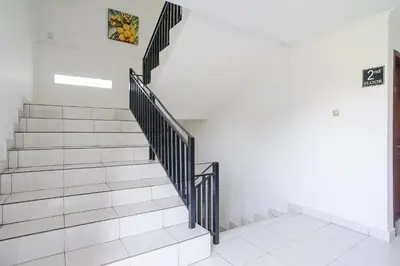 a staircase in a house with a sign on the wall at Gana Inn Legian in Legian