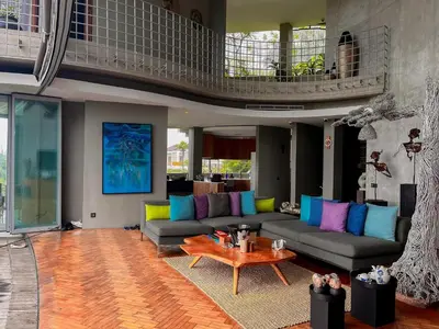 a living room with a couch and a table at Dacolina House in Jimbaran