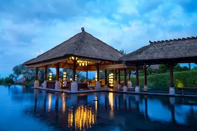 a resort with a pool at night at AYANA Villas Bali in Jimbaran