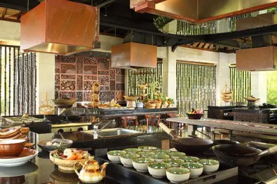 a large kitchen with many bowls of food in it at AYANA Villas Bali in Jimbaran