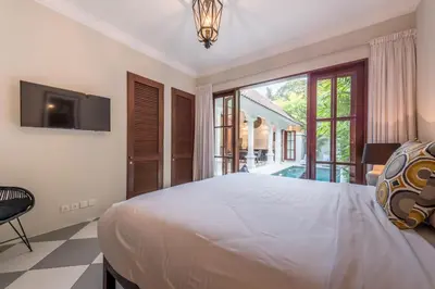 a bedroom with a large bed and a large window at Central 3 Bedroom Villa close to Seminyak Beach in Seminyak