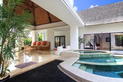 a villa with a swimming pool in front of a house at Villa Seminyak Estate & Spa - By Astadala in Seminyak