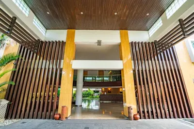 a lobby of a building with large wooden columns at Bintang Kuta Hotel in Kuta