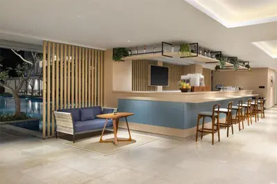 a hotel lobby with a bar and chairs at Hilton Garden Inn Bali Nusa Dua in Nusa Dua
