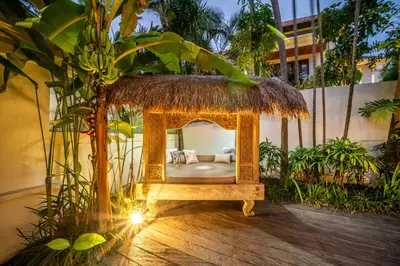 a bed in a room with a grass roof at Villa Koala, 2Br Close to W, Potato Head and Shi Shi in Seminyak