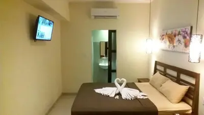 a bedroom with a bed with a white bow on it at Sari Stay in Jimbaran