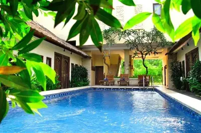 a swimming pool in front of a house at Sari Stay in Jimbaran