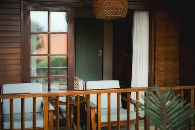 a porch with chairs and a door with a window at Fourteen Roses Boutique Hotel, Kuta in Legian