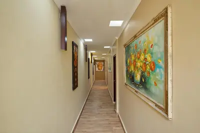 a hallway with a painting of flowers on the wall at Mahe Garden Kuta Villas by Kamara in Kuta