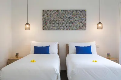 two beds sitting next to each other in a room at Villa Arif in Seminyak