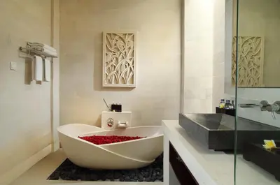 a bathroom with a white tub and a sink at Daluman Villas in Seminyak