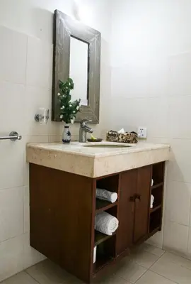 a bathroom with a sink and a mirror at Sunhouse Guesthouse in Sanur