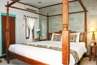 a bedroom with a large bed in a room at Sunhouse Guesthouse in Sanur
