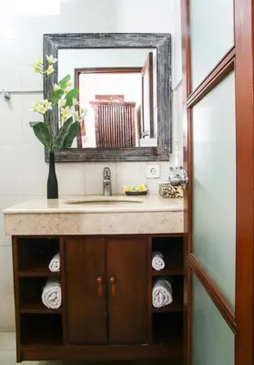 a bathroom with a sink and a mirror at Sunhouse Guesthouse in Sanur