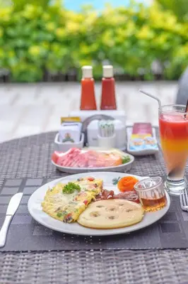 a table with two plates of food and a drink at d'Penjor Seminyak in Seminyak