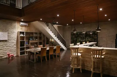 a dining room with a table and chairs and a staircase at Villa Latour in Seminyak
