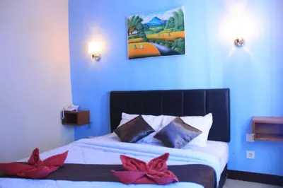 a bedroom with a bed with red flowers on it at Asher Bali Transit in Kuta