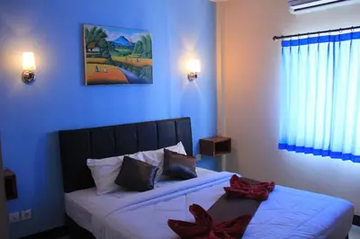 a bedroom with a bed with red bows on it at Asher Bali Transit in Kuta
